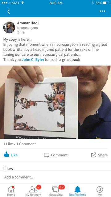 Dr. Ammar Hadi holding a copy of 'You Look Great!' by John C. Byler